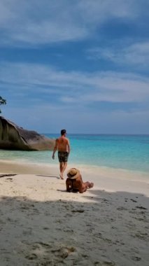 Similan Adaları Tayland, turkuvaz renkli okyanusları olan tropikal bir plaj, Similan Adaları 'na tekne gezisinde birkaç erkek ve kadın, beyaz plajda güneşleniyorlar.