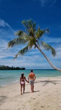 Koh Kood Adası Tayland 'da tatil yapan bir çift orta yaşlı erkek ve kadın. Beyaz tropikal plajları ve turkuaz renkli okyanus manzaralı palmiyeleri var.