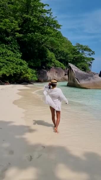 タイのシミラン島のビーチを歩くアジア系タイ人女性タイのシミラン島でターコイズブルーの海を持つ熱帯のビーチ — ストック動画