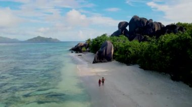 Anse Source dArgent, La Digue Seyşeller, Seyşeller 'de lüks bir tatil sırasında tropikal plajda bir çift. Tropik sahil Anse Kaynağı dArgent, Gün batımında La Digue Seyşeller