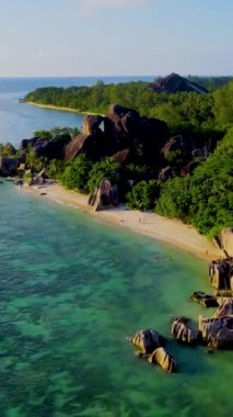 Anse Source dArgent, La Digue Seychelles, Seyşeller 'de lüks bir tatil sırasında tropikal plajda bir çift. Tropik sahil Anse Kaynağı dArgent, Gün batımında La Digue Seyşeller