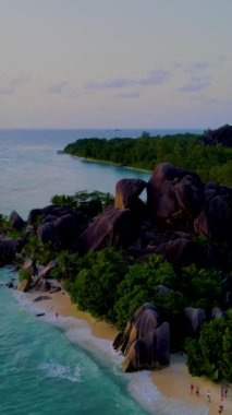 Günbatımında Anse Source dArgent plajı, Seyşeller 'de lüks bir tatilde günbatımında tropikal bir plaj olan La Digue Seychelles. Tropik sahil Anse Kaynağı dArgent, Gün batımında La Digue Seyşeller