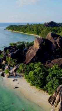 Günbatımında Anse Source dArgent plajı, Seyşeller 'de lüks bir tatilde günbatımında tropikal bir plaj olan La Digue Seychelles. Tropik sahil Anse Kaynağı dArgent, Gün batımında La Digue Seyşeller