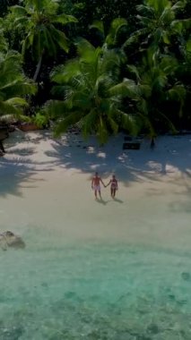 Anse Lazio Praslin Seyşeller. Tropikal bir plajda, palmiye ağaçları ve turkuaz renkli okyanuslarla lüks bir tatil yapan genç bir çift.