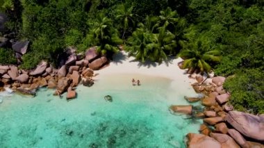 Anse Lazio Praslin Seyşeller. Tropikal bir plajda, palmiye ağaçları ve turkuaz renkli okyanuslarla lüks bir tatil yapan genç bir çift.