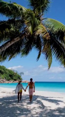 Anse Georgette Praslin Seyşeller, Seyşeller 'de lüks bir tatil sırasında tropik bir plajda yaşayan genç bir çift.. 