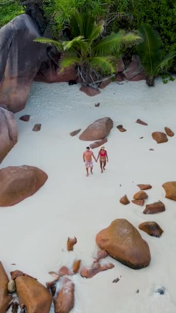 アンセ ラツィオ プラスリン セイシェルは セーシェルの豪華な休暇中に熱帯のビーチで若い男女のカップルです 巨大な岩のある白い熱帯のビーチ — ストック動画