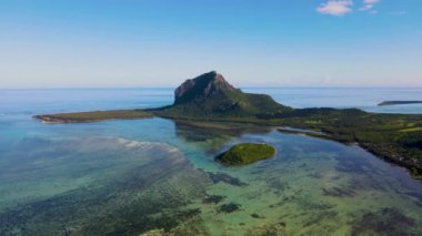 Le Morne plajı Mauritius Tropikal plajı. Palmiye ağaçları, beyaz kum mavisi okyanus ve şemsiyeli plaj yatakları, güneş sandalyeleri ve tropik bir sahildeki palmiye ağacının altında şemsiyeler. Mauritius 
