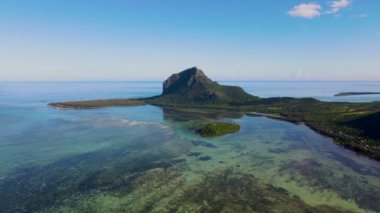 Le Morne plajı Mauritius Tropikal plajı. Palmiye ağaçları, beyaz kum mavisi okyanus ve şemsiyeli plaj yatakları, güneş sandalyeleri ve tropik bir sahildeki palmiye ağacının altında şemsiyeler. Mauritius 