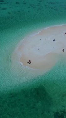 Koh Lipe Tayland 'da tatilde olan birkaç beyaz erkek ve Taylandlı kadın Koh Lipe Lipe' nin mercan kayalığındaki bir kumsalda yürüyorlar.