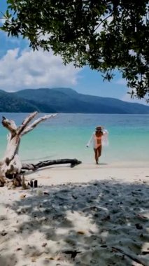 Taylandlı kadınlar Ko Ra Wi Adası Tarutao Ulusal Parkı, Satun Eyaleti, Tayland sahillerinde yürüyorlar.
