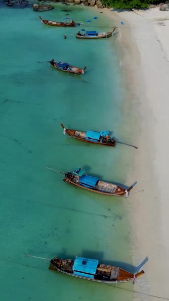 在泰国的Koh Lipe岛上 在一个阳光灿烂的日子里 泰国的Koh Lipe从空中俯瞰着蓝绿色海洋中的长尾船 海滩上的无人机俯瞰 — 图库视频影像