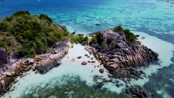 一对男女情侣在泰国Koh Lipe度假 在Koh Lipe岛珊瑚礁前的一个神奇的热带海滩上 他们看到了长尾小船和皮划艇 — 图库视频影像