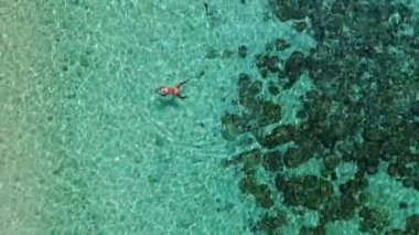 Mercan resifinde yüzen Asyalı kadınlar, Tayland 'ın Trang kentindeki Koh Kradan adasının havadan görünüşü. Mercan resifi ve turkuaz renkli okyanus drone manzaralı tropik plaj.