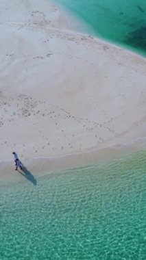 Yazın güneşli bir günde Koh Lipe Tayland 'da, Koh Lipe Tayland' ın mercan kayalığındaki bir kumsalda yürüyüş yapan bir çift erkek ve kadın.