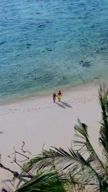 Tayland, Trang 'daki Koh Kradan adasının havadan görüntüsü. Yaz boyunca mercan kayalıkları ve turkuaz renkli okyanusları olan tropik plajlar, sahilde birkaç erkek ve kadın.