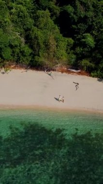Tayland, Trang 'daki Koh Kradan adasının havadan görüntüsü. Yaz boyunca mercan kayalıkları ve turkuaz renkli okyanusları olan tropik plajlar, KLoh Kradan Adası 'ndaki plajda birkaç erkek ve kadın.