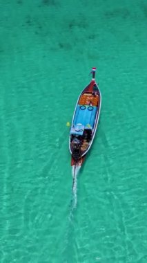 Tayland, Trang 'daki Koh Kradan adasının mavi okyanusunda uzun kuyruklu tekne. Yaz boyunca mercan resifi ve turkuaz renkli okyanusu olan tropik plaj.