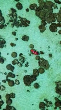Yazın güneşli bir günde Koh Lipe Tayland 'da, Koh Lipe Okyanusu' ndaki kayalıklarda kayak yapan bir çift erkek ve kadın.
