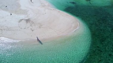 Yazın güneşli bir günde Koh Lipe Tayland 'da, Koh Lipe Tayland' ın mercan kayalığındaki bir kumsalda yürüyüş yapan bir çift erkek ve kadın.