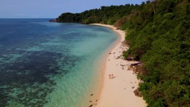 Trang Tayland 'daki tropikal ada Koh Kradan' da yürüyen bir çift kadın ve erkek. Turkuaz renkli okyanuslu güzel bir plaj.