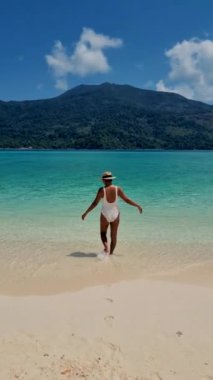 Koh Lipe Tayland 'da tatilde olan kadınlar yazın güneşli bir günde Koh Lipe Tayland' ın mercan kayalıklarında bir kumsalda yürüyorlar.