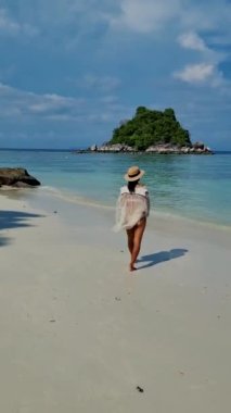 Koh Lipe Tayland 'da tatilde olan kadınlar yazın güneşli bir günde Koh Lipe Tayland' ın mercan kayalıklarında bir kumsalda yürüyorlar.
