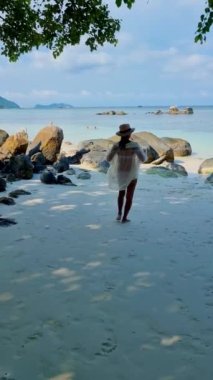 Koh Lipe Tayland 'da tatilde olan kadınlar yazın güneşli bir günde Koh Lipe Tayland' ın mercan kayalıklarında bir kumsalda yürüyorlar.