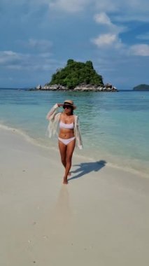 Koh Lipe Tayland 'da tatilde olan kadınlar yazın güneşli bir günde Koh Lipe Tayland' ın mercan kayalıklarında bir kumsalda yürüyorlar.