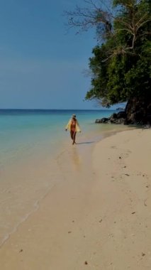 Tayland 'ın Trang kentindeki Koh Kradan adasında yaşayan Asyalı kadınlar. Mercan resifi ve turkuaz renkli okyanus drone manzaralı tropik plaj.