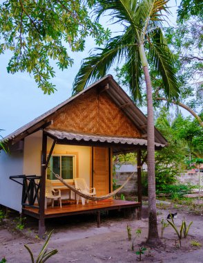 Tayland 'da sahilde bambu kulübeler. Tayland 'da bir bahçede basit bir sırt çantalı konaklama yeri
