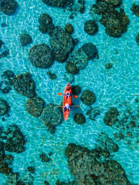 Ko Lipe Tayland adasının önündeki küçük bir adada kanoyla gezen çift.