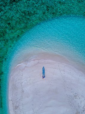 Tayland 'ın Ko Lipe Adası sahilinde bir çift kadın ve erkek. Okyanustaki bir kumsalın insansız hava görüntüsü