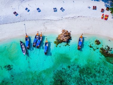 Tayland 'daki Koh Lipe adasının sahilinde drone görüntüsü, Ko Lipe okyanusunda uzun kuyruklu tekneler. 