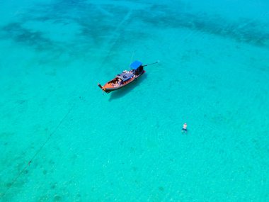 Tayland 'daki Koh Kradan adasının kumsalında insansız hava aracı görüntüsü, okyanusta uzun kuyruklu teknelerle Koh Kradan Adası Trang üzerinde havadan görüş.