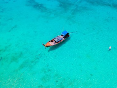 Tayland 'daki Koh Kradan adasının kumsalında insansız hava aracı görüntüsü güneşli bir günde okyanusta uzun kuyruklu teknelerle Koh Kradan Adası üzerinde hava manzarası.