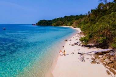 Tayland 'da Koh Kradan adasının kumsalında insansız hava aracı görüntüsü, Koh Kradan Adası üzerinde hava manzarası, Tayland' da tatil sırasında sahilde birkaç kadın ve erkek.