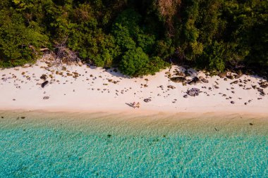 Tayland 'da Koh Kradan adasının kumsalında insansız hava aracı görüntüsü, Koh Kradan Adası üzerinde hava manzarası, Tayland' da tatil sırasında sahilde birkaç kadın ve erkek.
