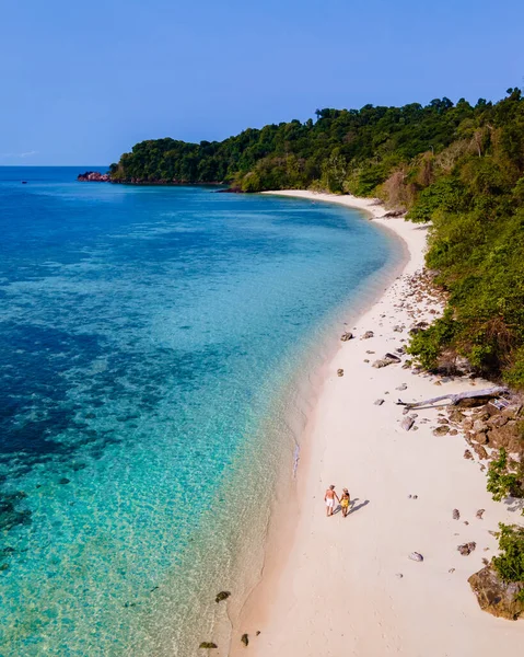 stock image drone view at the beach of Koh Kradan island in Thailand, aerial view over Koh Kradan Island Trang, couple of men and women on the beach