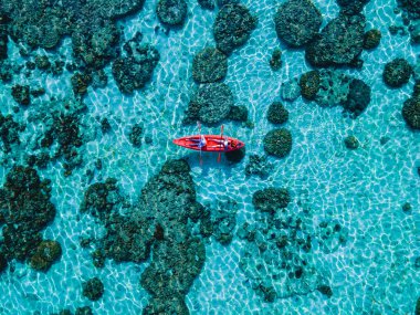 Koh Lipe Adası 'nın önündeki Kla Adası sahilinde turkuvaz renkli okyanusları ve güneşli bir günde Ko Lipe' de kanosu olan beyaz kumlu plajları olan bir çift.