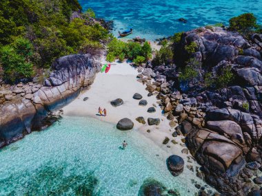 Koh Lipe Adası 'nın önündeki Kla Adası sahilinde turkuvaz renkli okyanusları ve güneşli bir günde Ko Lipe' de kanosu olan beyaz kumlu plajları olan bir çift.