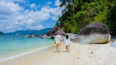 couple on beach in swimwear at Koh Adang Island near Koh Lipe Island Southern Thailand with turqouse colored ocean and white sandy beach Tarutao National Park clipart