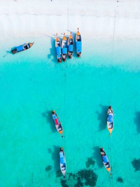 Koh Lipe Adası 'nın mavi okyanusunda renkli uzun kuyruklu tekneler. Güney Tayland' da turkuaz renkli okyanuslar ve Ko Lipe 'de beyaz kumlu plajlar..