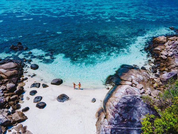 Koh Lipe Adası 'nın önündeki Kla Adası sahilinde turkuvaz renkli okyanusları ve güneşli bir günde Ko Lipe' de kanosu olan beyaz kumlu plajları olan bir çift.