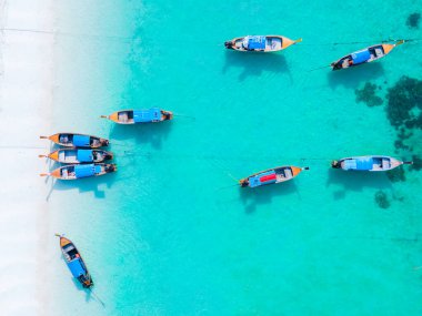Koh Lipe Adası 'nın mavi okyanusunda renkli uzun kuyruklu tekneler. Güney Tayland' da turkuaz renkli okyanuslar ve Ko Lipe 'de beyaz kumlu plajlar..