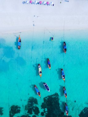 Koh Lipe Adası 'nın mavi okyanusunda turkuaz renkli okyanusları ve beyaz kumlu kumsalları olan uzun kuyruklu tekneler. 
