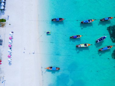 Koh Lipe Adası 'nın mavi okyanusunda turkuaz renkli okyanusları ve beyaz kumlu kumsalları olan uzun kuyruklu tekneler. 