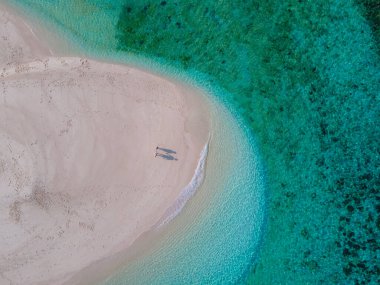 Koh Lipe Adası Güney Tayland 'da beyaz bir kumsalda, turkuaz renkli okyanuslar ve güneşli bir günde Ko Lipe' de beyaz kumsallı bir kumsalda bir çift kadın ve erkek.