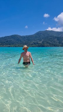 Koh Lipe Adası 'nın güney Tayland sahillerinde kısa yüzen genç erkekler. Turkuaz renkli okyanusları ve Ko Lipe' de beyaz kumlu plajları var..