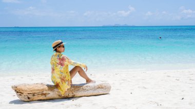 Koh Lipe Adası Güney Tayland Turkuaz renkli okyanusları ve Ko Lipe 'de beyaz kumlu plajları var. Tayland 'da tatilde olan Asyalı bir kadın sahilde yürüyor.